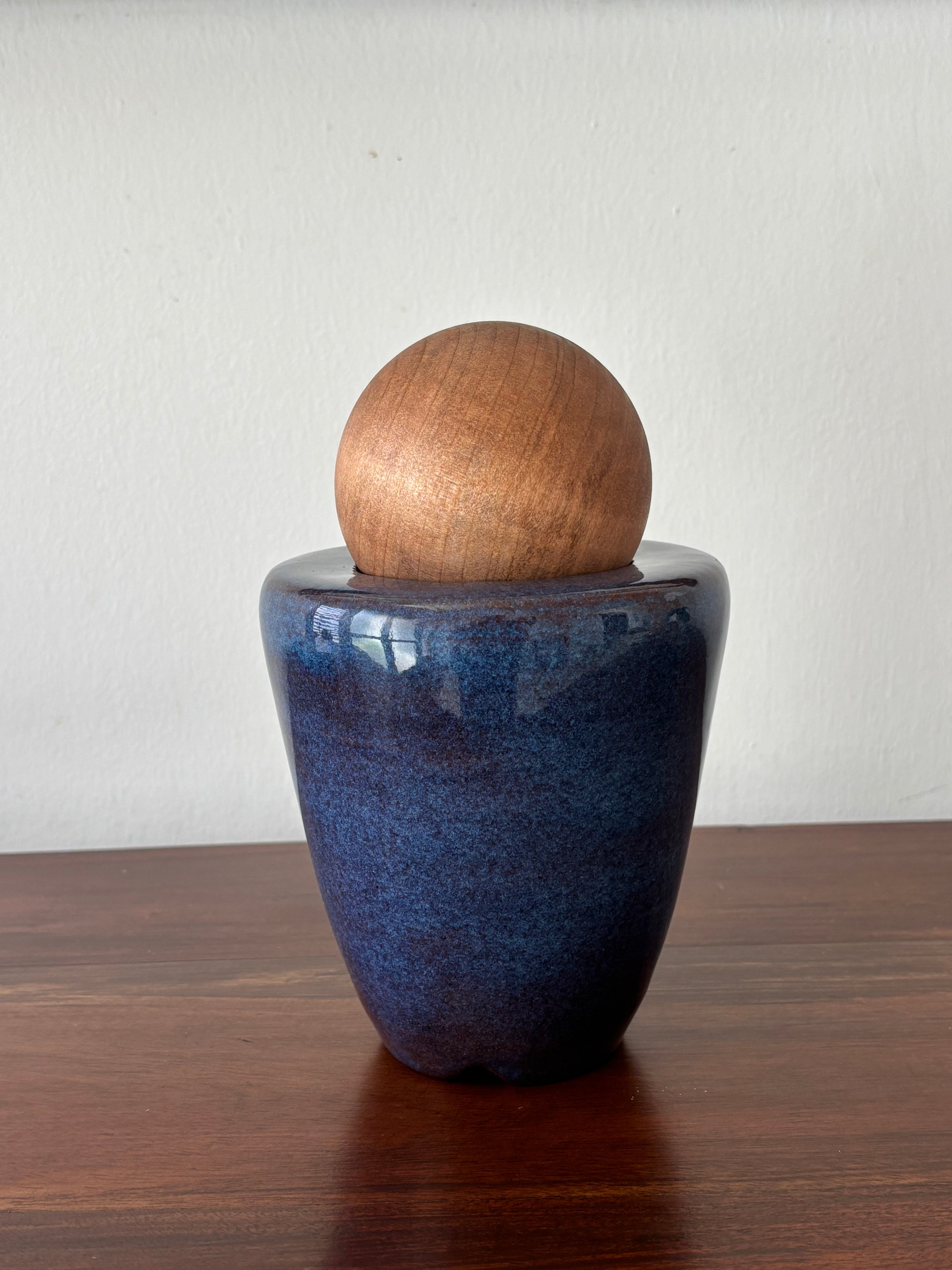 Vasija azul con esfera de madera