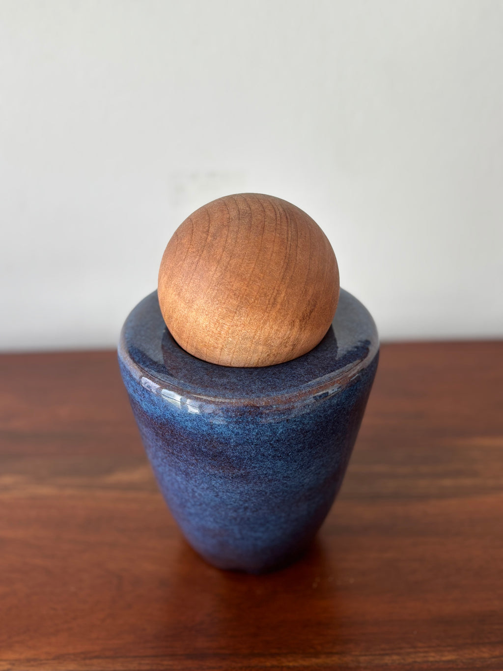 Vasija azul con esfera de madera