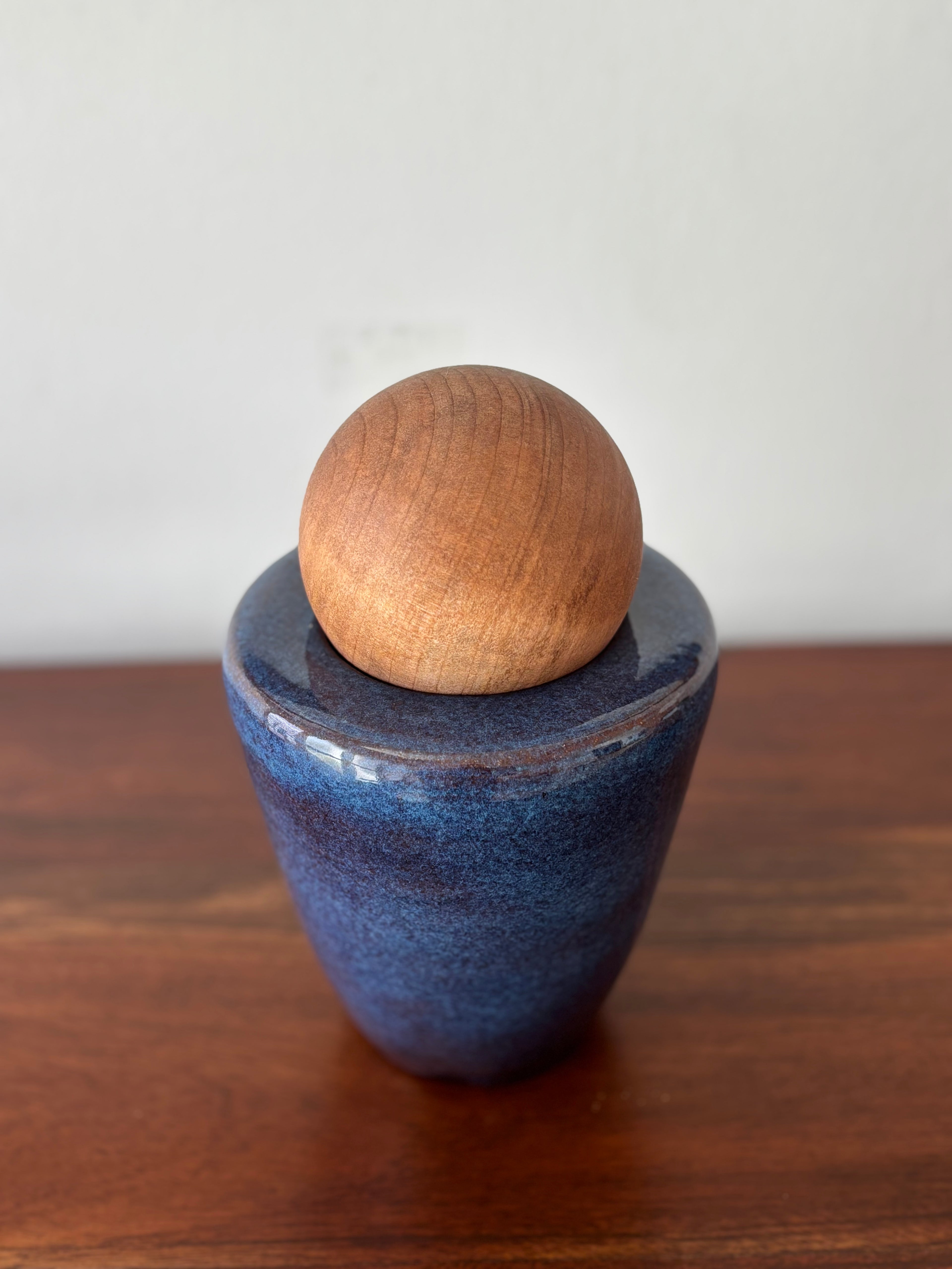 Vasija azul con esfera de madera