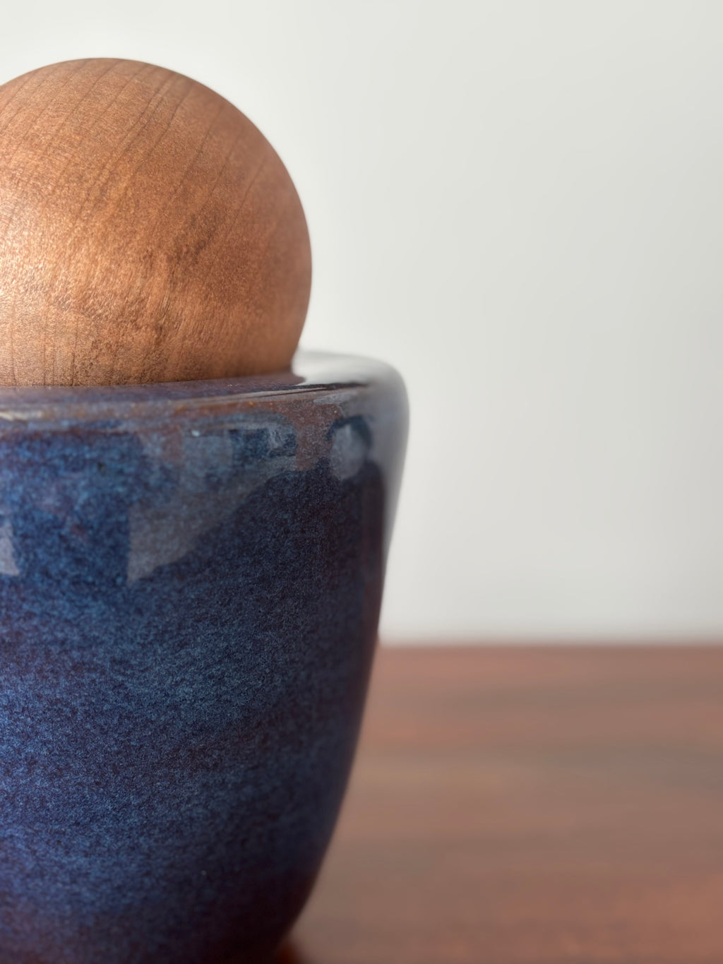 Vasija azul con esfera de madera